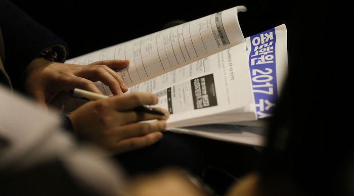 메인이미지  1 : 12일 오후 서울 성동구 행당동 한양대학교 체육관에서 열린 종로학원 '대폭 바뀐 수능에 따른 대학입시전략 설명회'에서 참석자가 자료를 살펴보고 있다.