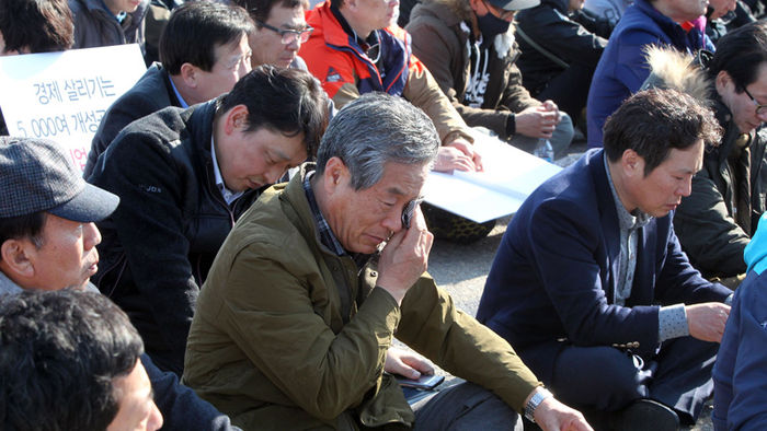 메인이미지  7 : 16일 오후 경기도 파주시 통일대교에서 개성공단 입주기업과 협력기업 임직원과 가족들이 '개성공단 평화대행진'을 하다가 잠시 앉아 집회를 하던 중 흐르는 눈물을 닦고 있다.