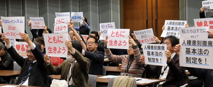 메인이미지  2 : 17일 오후 일본 도쿄도(東京都) 지요다(千代田)구 소재 참의원 의원회관에서 열린 집회에서 참석자들이 인종차별금지법 제정을 요구하는 문구를 비롯해 일본 내 차별을 없애자는 뜻을 담은 종이를 들어 보이고 있다. 