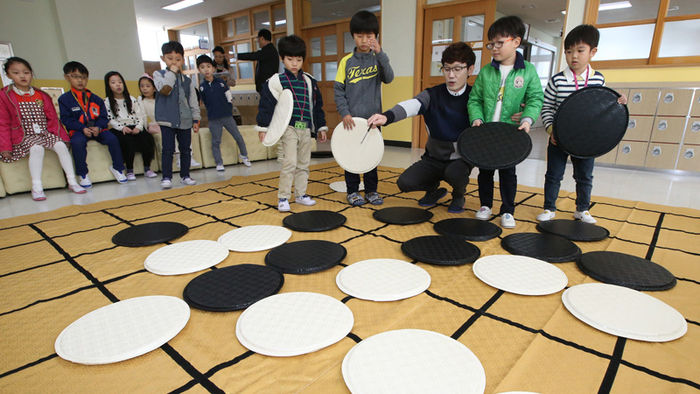 메인이미지  1 : 21일 세종시 양지초등학교(교장 박대응)에서 진행된 바둑 방과 후 수업에서 학생들이 대형 바둑판과 돌을 이용, '돌 따내기와 돌 살리기' 수업을 받고 있다.