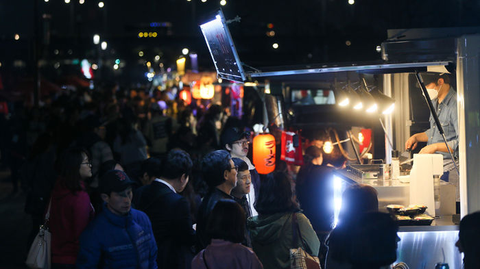 메인이미지  3 : 31일 서울 여의도 한강공원 물빛광장에서 시민들이 '서울 밤 도깨비 야시장'을 둘러보고 있다 .