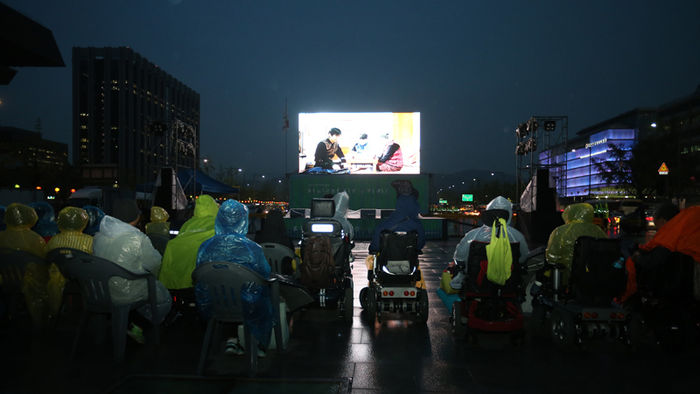 메인이미지  3 :  20일 장애인의 날을 맞아 서울 광화문광장에서 열린 제14회 서울장애인인권영화제에서 참석자들이 개막작 '영우'를 관람하고 있다.