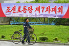 섬네일이미지  1:'김정은 시대'의 선포를 공식화하는 북한의 제7차 노동당 대회가 6일 열렸다. 사진은 대회가 열리는 평양 4&middot;25 문화회관 주변에 설치된 당 대회 알림판 아래를 한 주민이 자전거를 끌고 지나가고 있다.