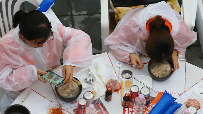 메인이미지  5 : 6일 오후 서울 반포한강공원에서 열린 중국 건강보조제품 제조회사 중마이그룹 삼계탕 파티에서 한 직원이 식사를 하기 전 휴대전화로 삼계탕을 촬영하고 있다. 