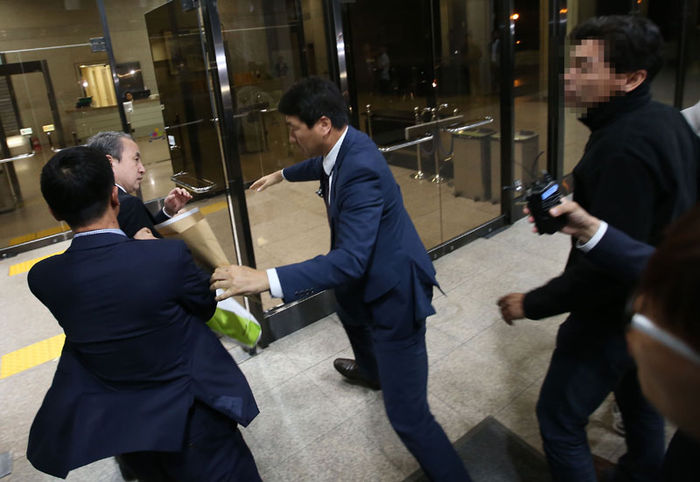 메인이미지  2 : 가습기 살균제 사망 사건을 수사하는 검찰이 가해업체 관계자들을 처음으로 구속했다. 2011년 사태가 불거진 지 5년 만의 형사처벌이다. 서울중앙지검 특별수사팀은 안전성 검사 없이 유해 제품을 제조&middot;판매해 사람을 숨지거거나 다치게 한 혐의(업무상 과실치사 및 과실치상)로 옥시레킷벤키저(옥시) 신현우(68) 전 대표와 전 연구소장 김모씨, 선임연구원 최모씨를 14일 구속했다. 이날 검찰 조사를 마친 신 전 대표(왼쪽)가 서울 서초동 지검을 나서다 유가족의 항의를 받고 다시 안으로 들어가고 있다.