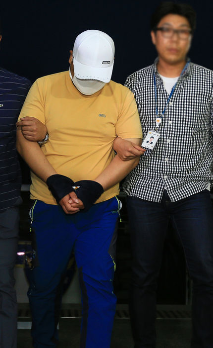 메인이미지  1 : 김호천 기자 = 제주에서 중국인 여성을 살해한 혐의로 긴급체포된 중국인 S(33)씨가 모자를 쓰고 고개를 숙인 채 형사들과 함께 경찰서로 들어오고 있다.