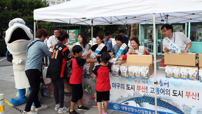 메인이미지  1 : 31일 오후 부산 사직야구장에서 부산시와 대형선망수산업협동조합이 고등어 소비를 촉진하고자 국립수산과학원의 기술지원을 받아 개발한 신제품 고등어 스낵 1만개를 나눠주고 있다.