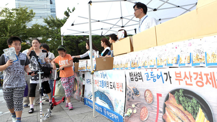 메인이미지  2 : 31일 오후 부산 사직야구장에서 부산시와 대형선망수산업협동조합이 고등어 소비를 촉진하고자 국립수산과학원의 기술지원을 받아 개발한 신제품 고등어 스낵 1만개를 나눠주고 있다.