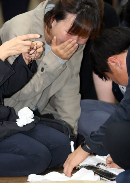 메인이미지  2 : 16일 경부고속도로 관광버스 화재사고 합동분향소가 차려진 울산 국화원에서 유가족들이 목걸이와 휴대전화 등 고인의 유류품을 확인하며 통곡하고 있다. 