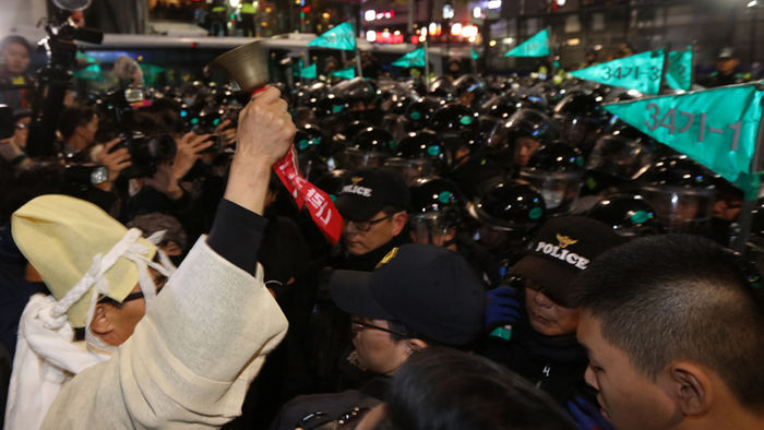 메인이미지  4 : 12일 서울 도심에서 열린 박근혜 대통령 퇴진 3차 촛불집회 참가 시민이 상여복을 입고 종로구 내자동 로터리에 대기 중인 경찰과 대치하고 있다.