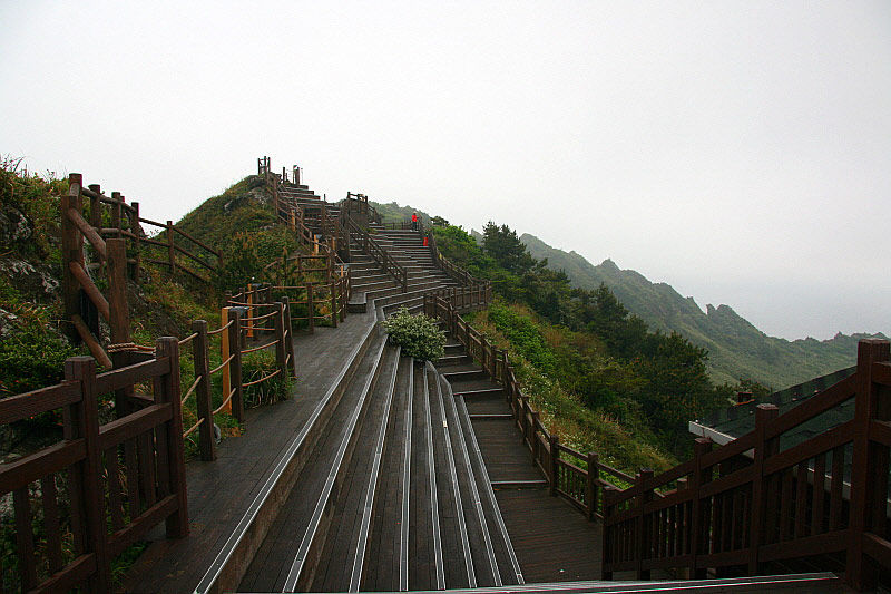 성산 일출봉 정상의 나무 데크 관람석에 앉아 분지와 바다와 나를 본다.