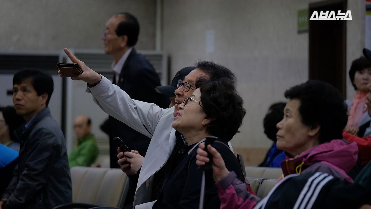 라이브 방송을 보며 반응을 하는 시민들