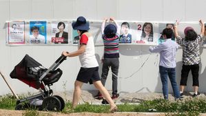 [슬라이드 포토] 담장에 붙은 선거 벽보…우리동네 차세대 리더는 누구?