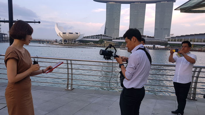 메인이미지  7 : 청와대가 13일 페이스북을 통해 문재인 대통령의 싱가포르 국빈방문 B컷을 공개했다. 청와대는 "<11시50분 청와대입니다>를 녹화 중인 고민정 부대변인, 이를 찍고 있는 싱가포르 관광객의 모습입니다."라고 밝혔다.