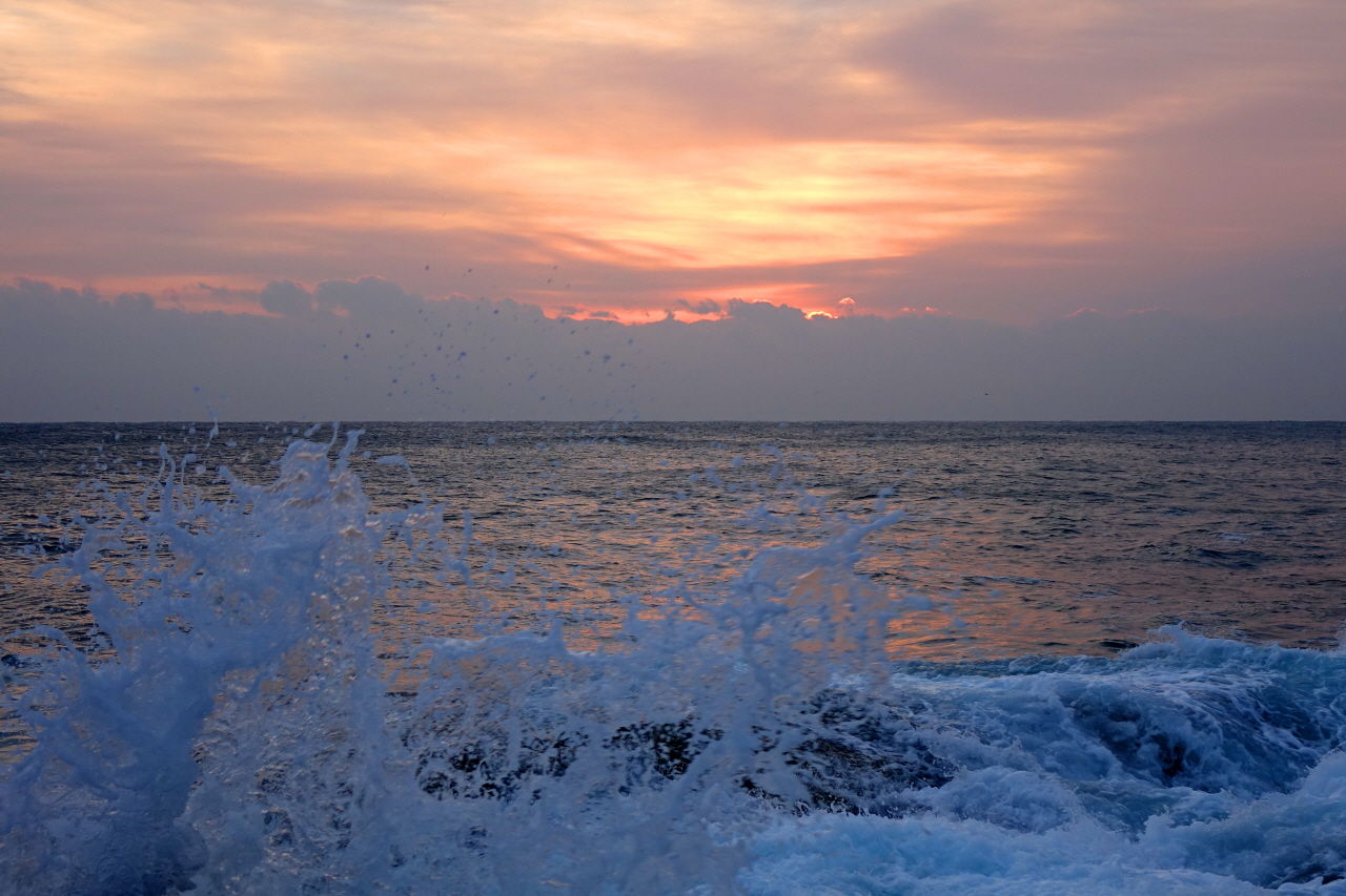 수평선 너머의 하늘이 붉게 물들기 시작한다.