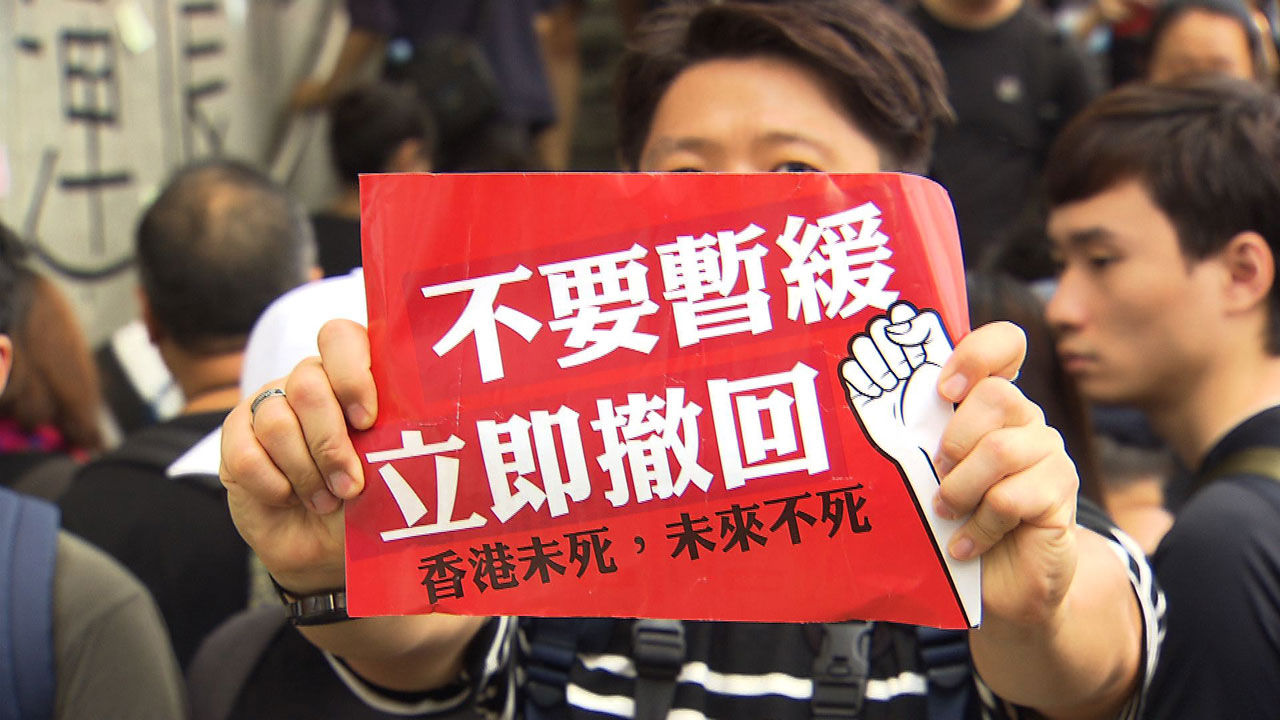 6월 16일 집회에 나선 한 참가자가 '범죄인 인도 법안 연기가 아닌 철회를 원한다'는 피켓을 들고 있다.