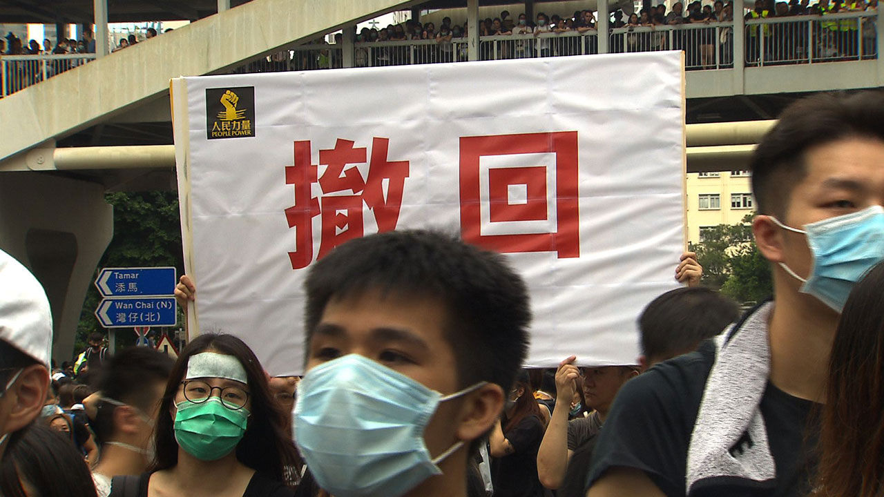 6월 12일 시위 참가자들은 모두 마스크를 썼다. 참가자들은 '철회'라는 구호가 적혀진 피켓을 들었다.