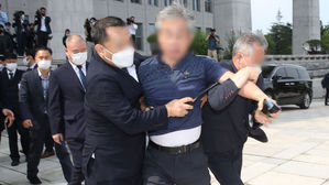 관계자에 의해 제지 당하는 정 모 씨