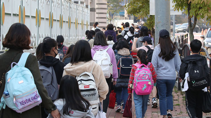 메인이미지  1 : 전국 유·초·중·고의 등교 인원 제한이 2/3로 완화된 19일 오전 경기도 고양시 일산동구의 한 초등학교 앞이 등교하는 학생과 배웅 나온 학부모 등으로 북적이고 있다.