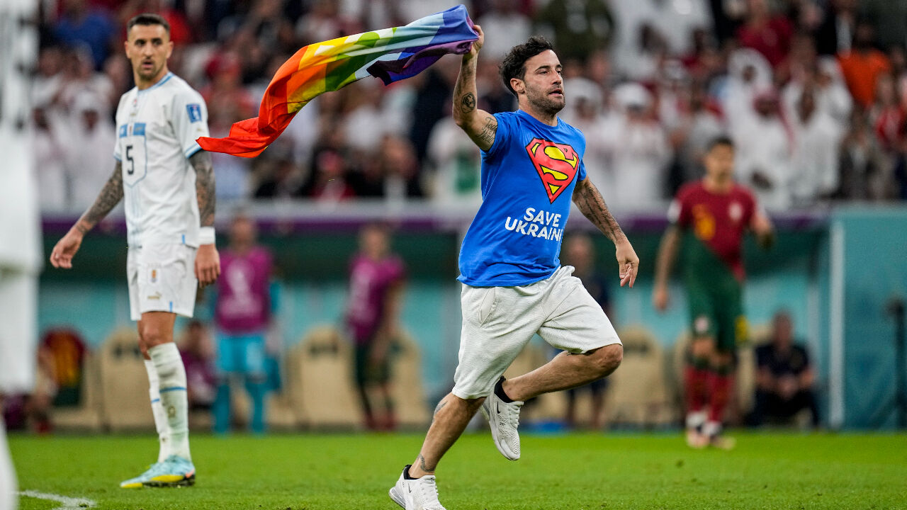 포르투갈과 우루과이의 2차전 경기에서 슈퍼맨 티셔츠를 입은 한 관중이 무지개색 깃발을 휘날리며 난입하는 소동이 벌어져 잠시 경기가 중단됐다. (사진=연합뉴스)