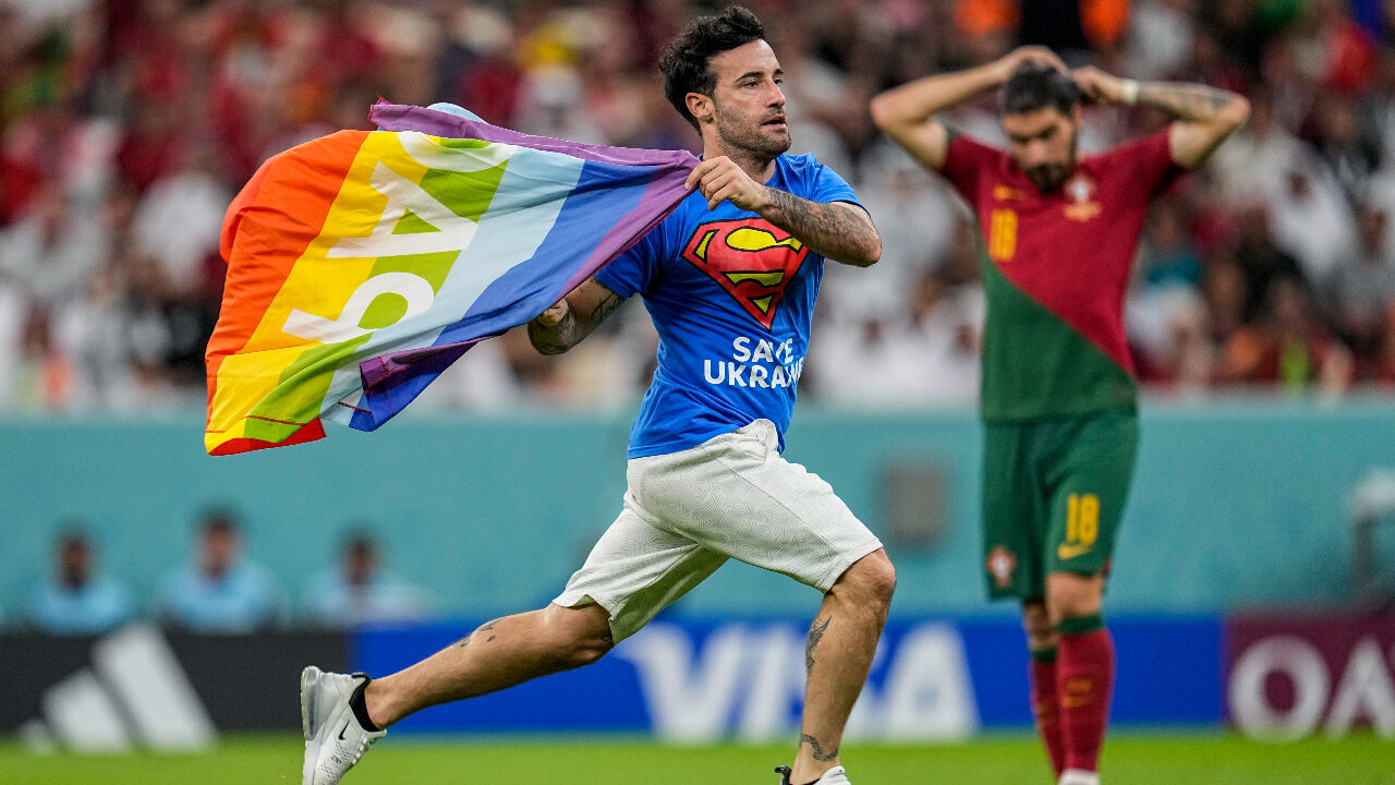 포르투갈과 우루과이의 2차전 경기에서 슈퍼맨 티셔츠를 입은 한 관중이 무지개색 깃발을 휘날리며 난입하는 소동이 벌어져 잠시 경기가 중단됐다. (사진=연합뉴스)