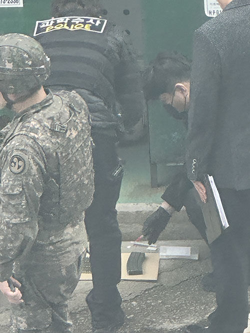 김해 한 아파트 헌옷수거함에서 공포탄과 탄창이 발견돼 군과 경찰이 현장을 확인하는 모습 (사진=독자 제공, 연합뉴스)
