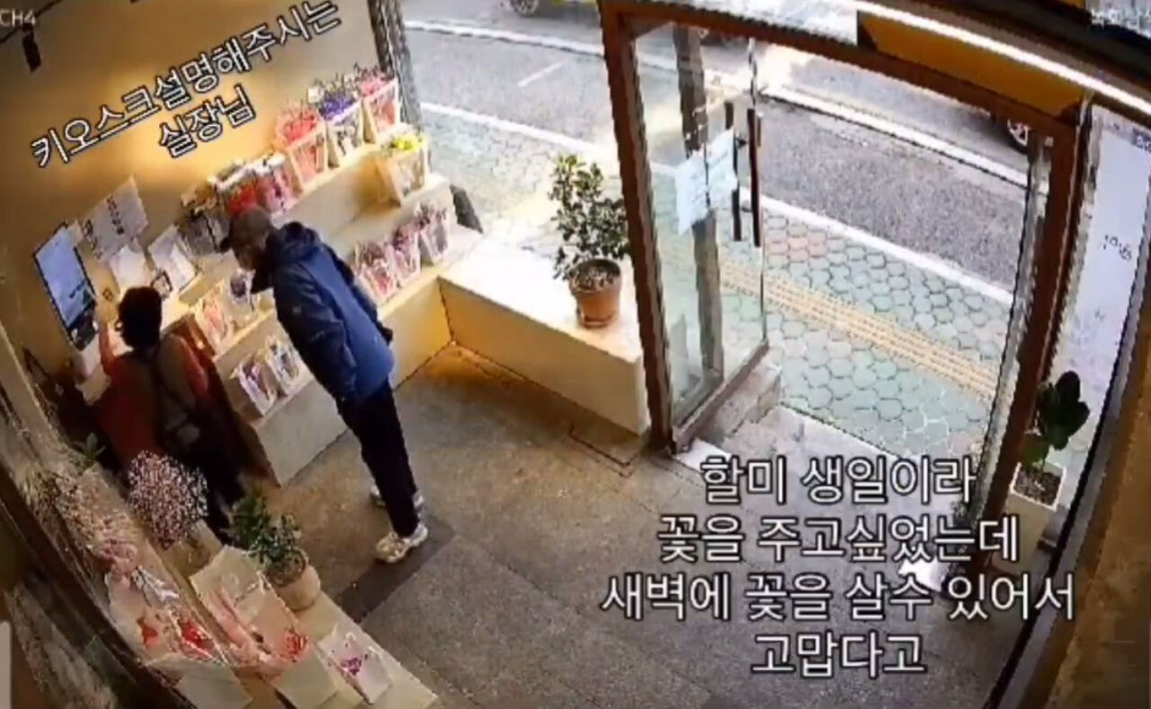 할아버지에게 키오스크 사용법에 대해 설명해 주는 모습.  