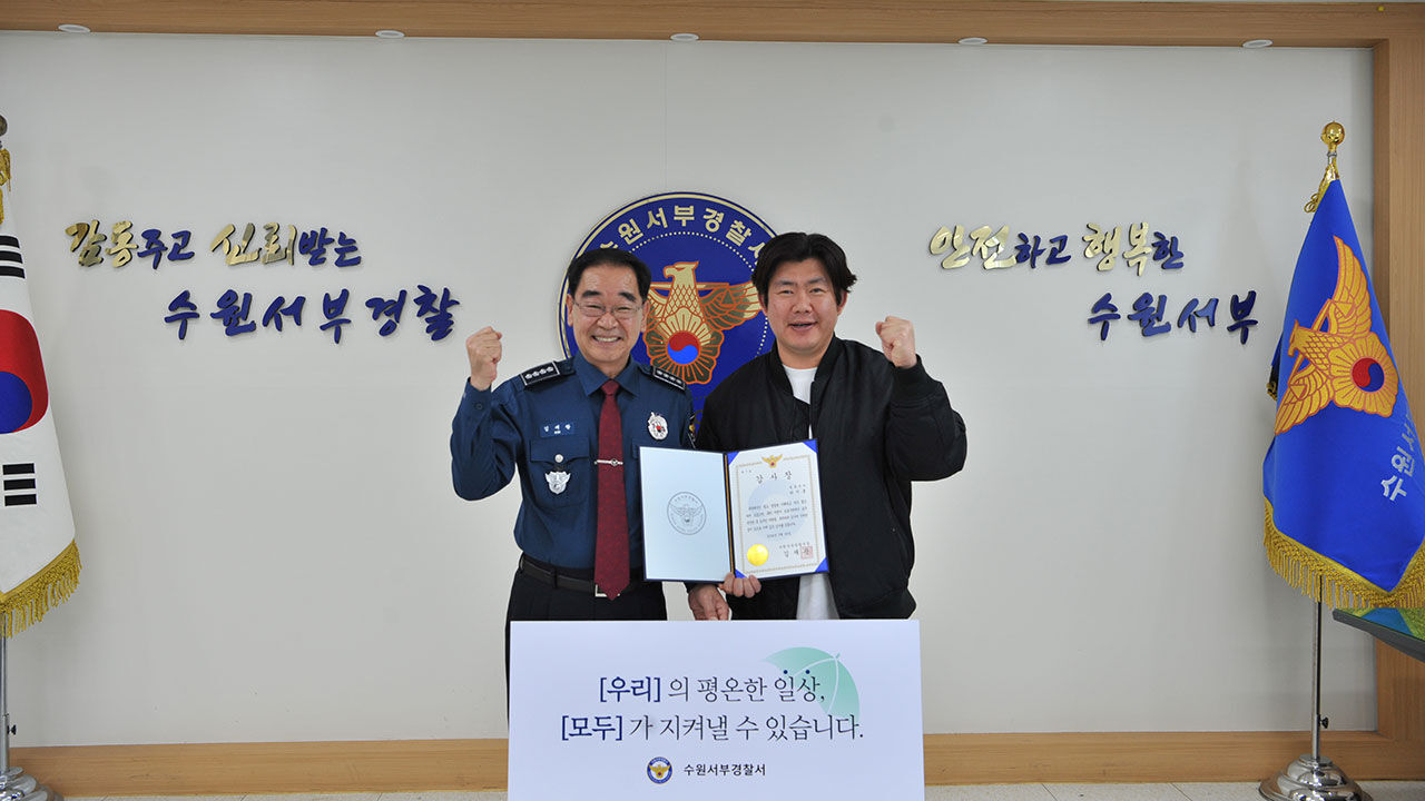 김재광 수원서부경찰서장(왼쪽)이 택시기사 박지훈씨에게 감사장을 수여하고 있다.
