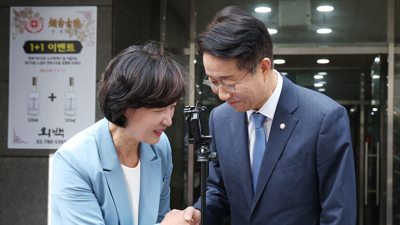 더불어민주당 추미애, 조정식 국회의장 경선 후보가 국회의장 단일화를 논의한 뒤 건물을 나와 악수하고 있다.