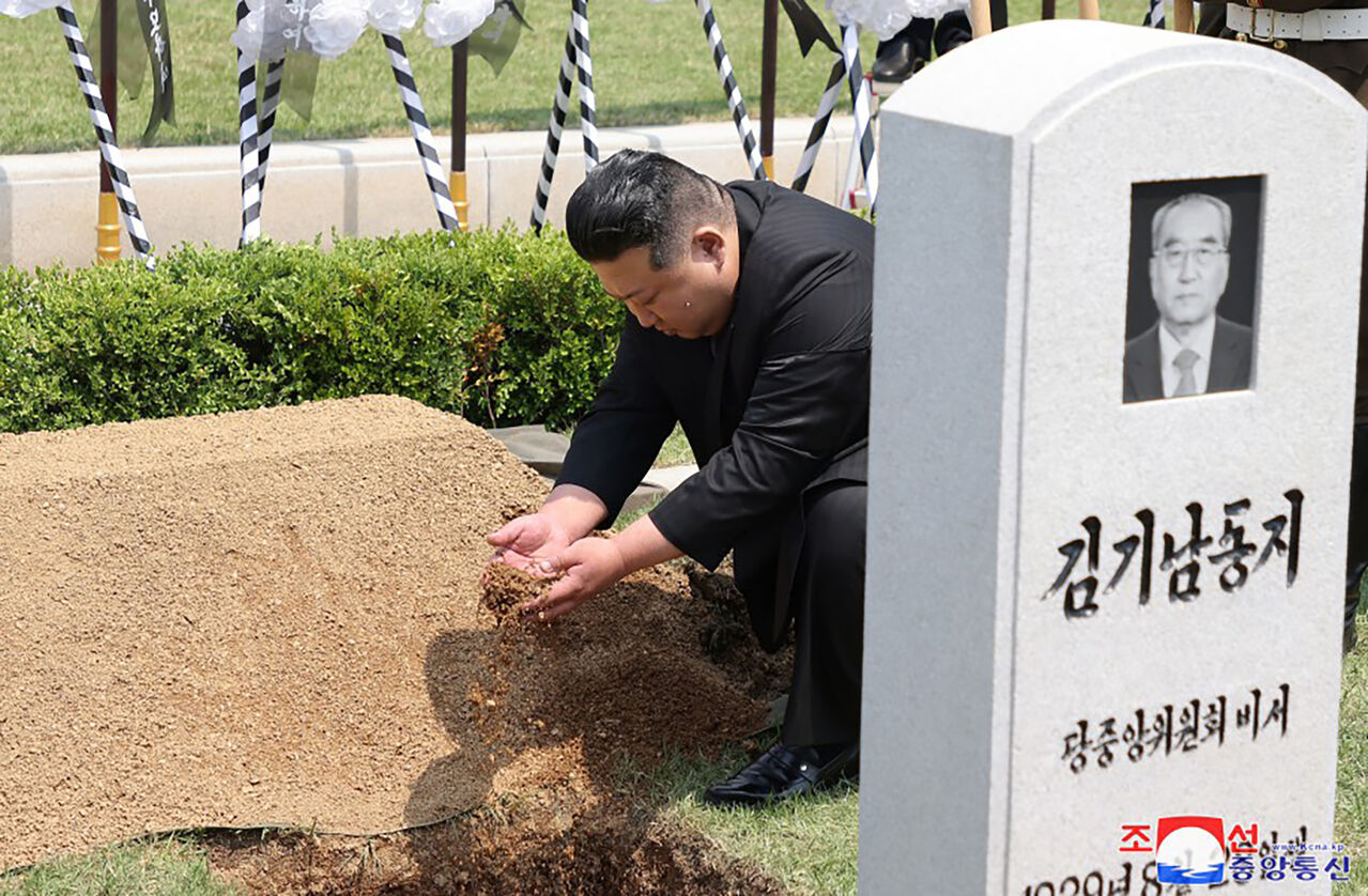 김기남의 유해가 묻히기 전 김정은이 흙을 뿌리고 있다.