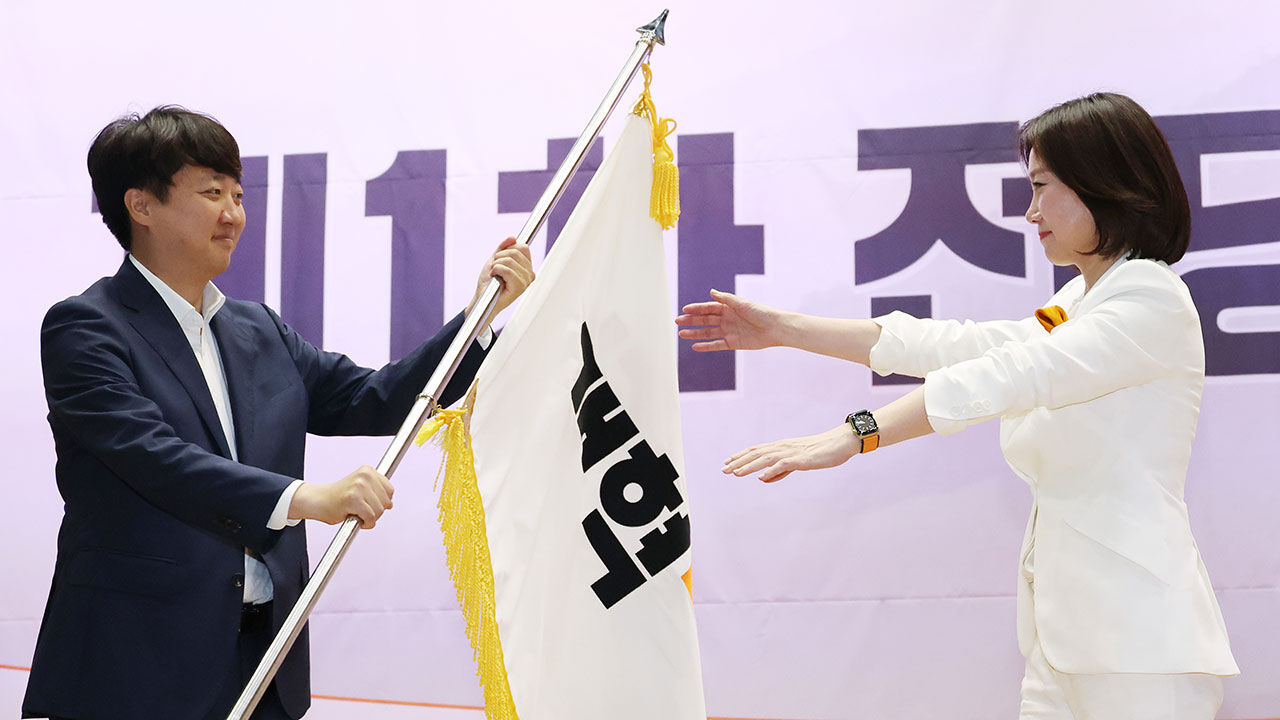 개혁신당 전당대회에서 신임 당 대표로 선출된 허은아 후보가 이준석 대표로부터 당기를 건네받고 있다.