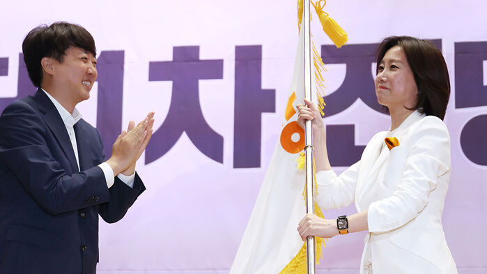 개혁신당 전당대회에서 신임 당 대표로 선출된 허은아 후보가 이준석 대표로부터 당기를 건네받고 있다.