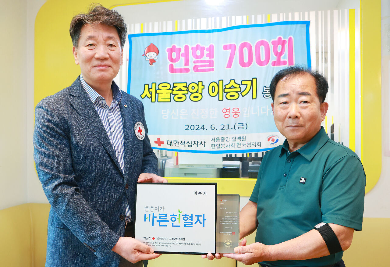 700회 헌혈을 달성한 헌혈자 이승기 씨(오른쪽)가 지난 21일 서울 강서구 대한적십자사 서울중앙혈액원에서 김상진 서울중앙혈액원장에게 감사패를 받은 뒤 인증 사진을 찍는 모습. 