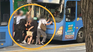시민들이 여성 구조하기 위해 버스를 들어올리는 모습. (사진=연합뉴스)