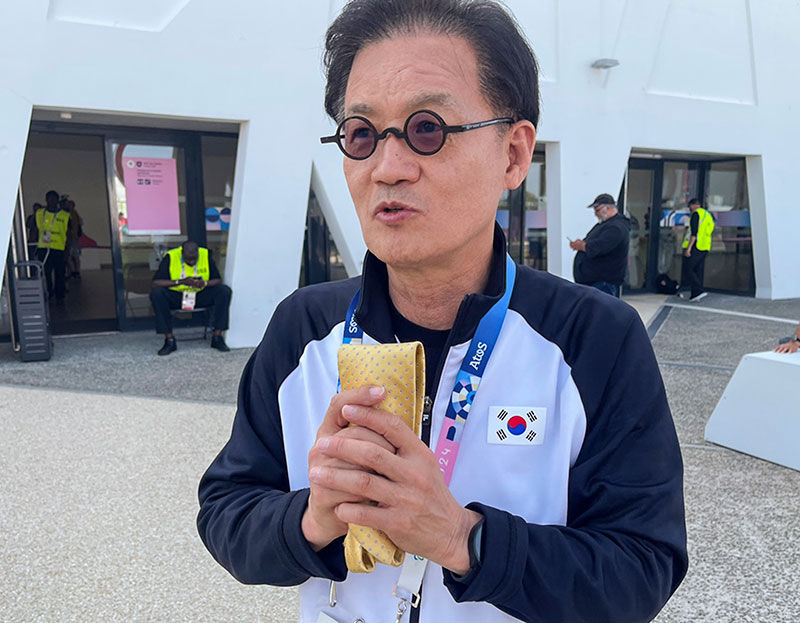 2024 파리 올림픽 사격 대표팀의 메달 레이스를 이끈 장갑석 총감독이 14년동안 경기마다 가지고 다닌 황금빛 넥타이를 들어 보이고 있다. (사진=연합뉴스)