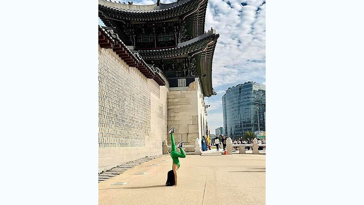 베트남 여성 관광객 H씨가 지난달 29일 한국 방문 도중 광화문 옆 경복궁 돌담 앞에서 전신 레깅스 차림으로 요가하는 모습. (사진=VN익스프레스 홈페이지 캡처, 연합뉴스)