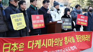 22일 서울 종로구 소녀상 앞에서 열린 일본 기자회견에서 대한민국독도협회 회원들이 손팻말을 들고 있다.