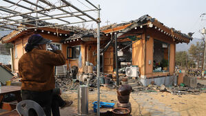 7일 오후 경기도 포천시 이동면 노곡리 공군 전투기 오폭 사고 현장에서 피해 주민이 파손된 집을 보며 물을 마시고 있다.