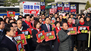국민의힘 윤재옥 의원이 21일 서울 종로구 헌법재판소 앞에서 열린 윤석열 대통령 탄핵 각하 촉구 기자회견에서 발언하고 있다. 국민의힘 기자회견 뒤쪽으로 더불어민주당 의원들이 윤 대통령의 즉각 파면을 촉구하는 손팻말을 들고 있다.