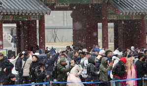 서울에 눈이 내린 30일 서울 경복궁에서 관광객들이 수문장 임명 의식을 지켜보고 있다.