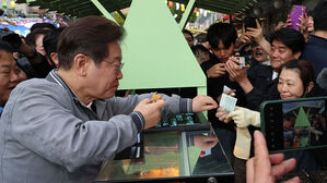 더불어민주당 이재명 대선 후보가 '골목골목 경청투어' 사흘째인 3일 강원도 태백시 장성동 산나물 축제장에서 붕어빵을 사먹으며 지역화폐를 사용하고 있다.