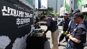 지난달 23일 서울 중구 서울고용노동청 앞에서 열린 산재사망 건설노동자 추모 위령제에서 참가자들이 헌화하고 있다.