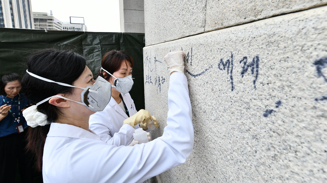 국립고궁박물관 전문가들이 낙서를 지우는 모습