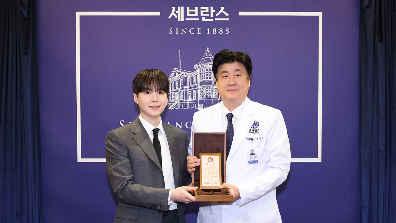 그룹 방탄소년단(BTS)의 슈가(왼쪽)와 금기창 연세의료원장이 기념 촬영하는 모습.
