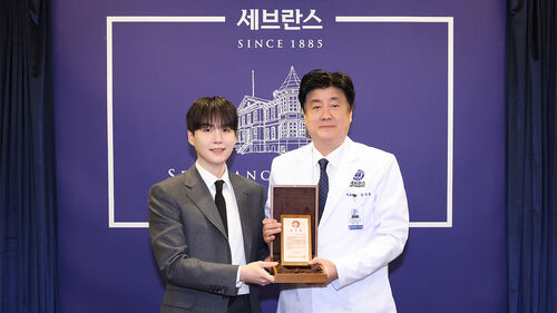 그룹 방탄소년단(BTS)의 슈가(왼쪽)와 금기창 연세의료원장이 기념 촬영하는 모습.