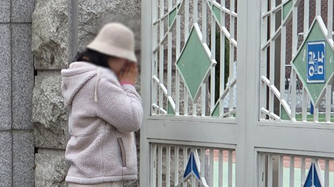 2026학년도 대학수학능력시험일인 13일 서울 광진구 광남고 교문 앞에서 한 어머니가 기도하고 있다.