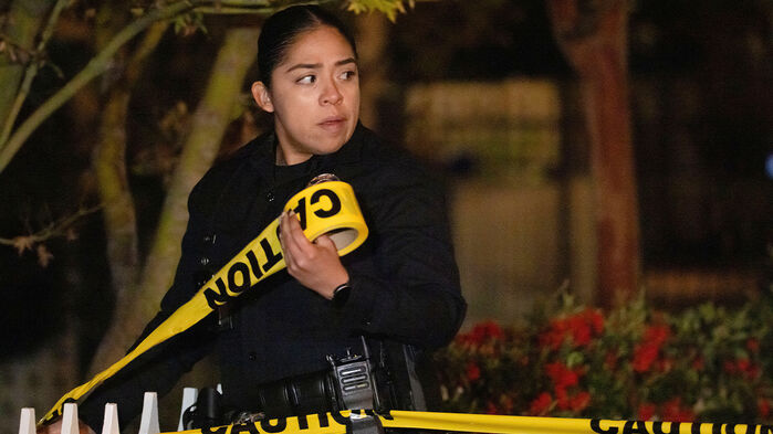 롭 라이너 영화감독의 자택 근처에서 경찰관이 수사 현장 주변에 폴리스 라인을 붙이고 있다.