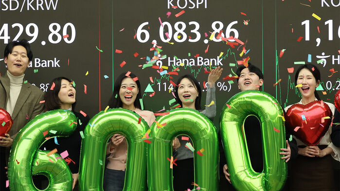 코스피가 사상 처음으로 6,000을 돌파해 거래를 마친 25일 서울 중구 하나은행 딜링룸에서 딜러들이 기념 세리머니를 하고 있다. (사진=연합뉴스)