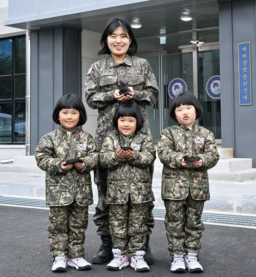 해군 제8전투훈련단 소속 이은주 상사와 세쌍둥이 딸들이 소아암 아동 돕기를 위해 자른 각 25cm 길이의 머리카락을 손에 들고 기념사진을 촬영하고 있다. 