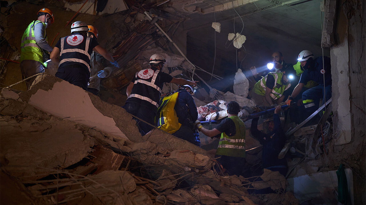 이스라엘 공습으로 붕괴한 레바논 베이루트의 건물에 부상자를 구출하는 응급대원들